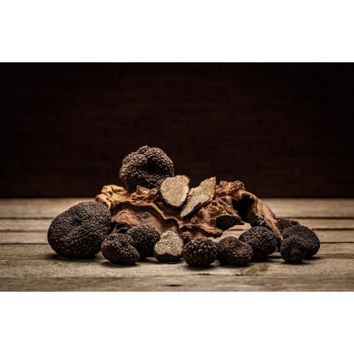 Zwarte truffels op een houten tafel met een zwarte achtergrond